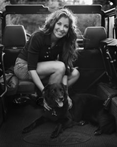Dylan Lauren seated with her dog