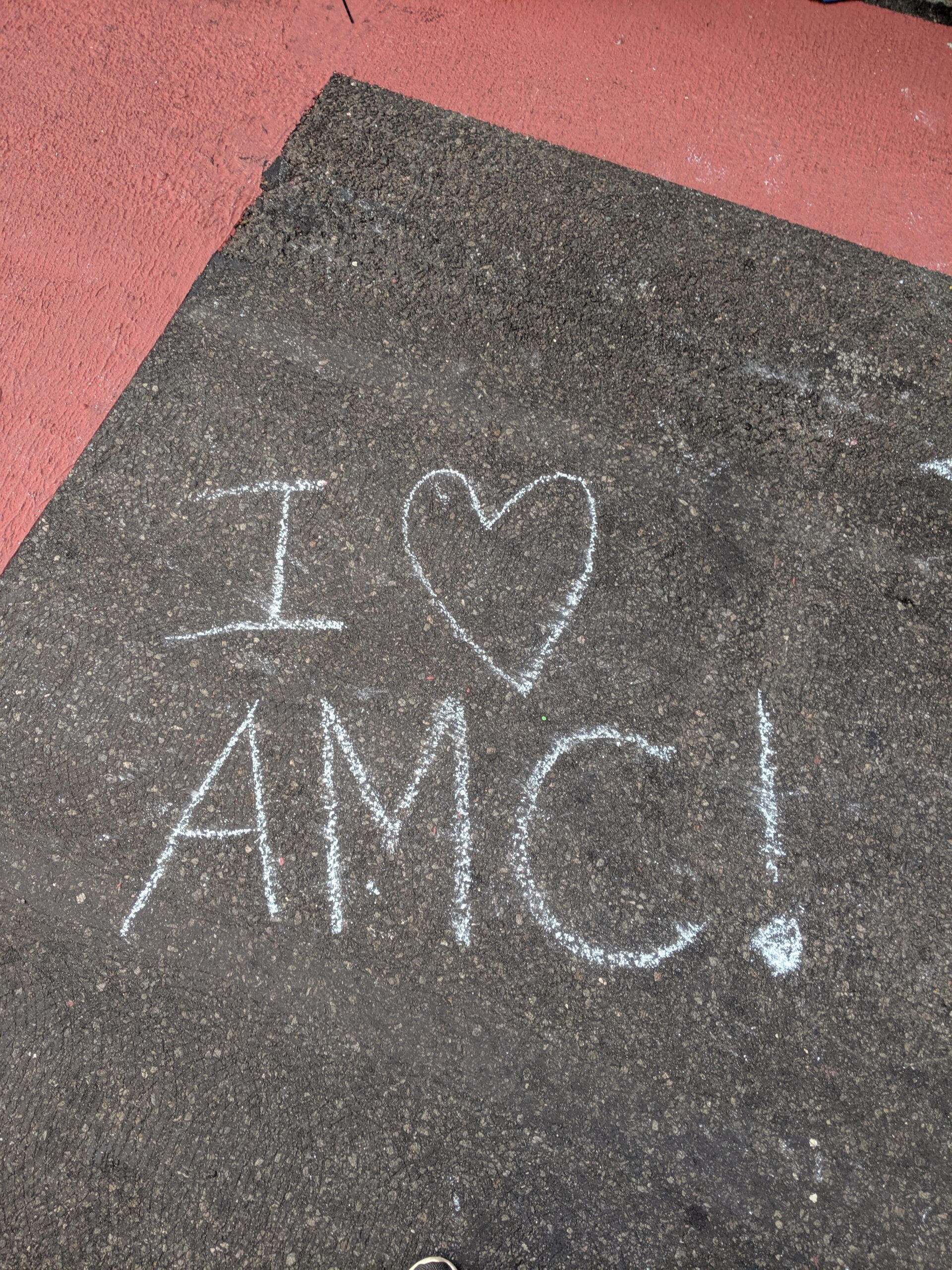 I heart AMC written on pavement in chalk