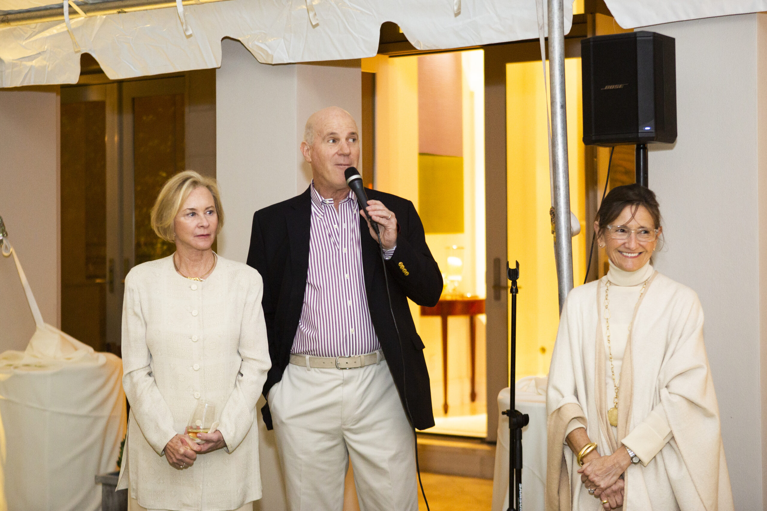 AMC CEO Kate Coyne, AMC CAO Neil McCarthy, and Elizabeth Monaco address a crowd at a fundraising event in Wellington, Florida