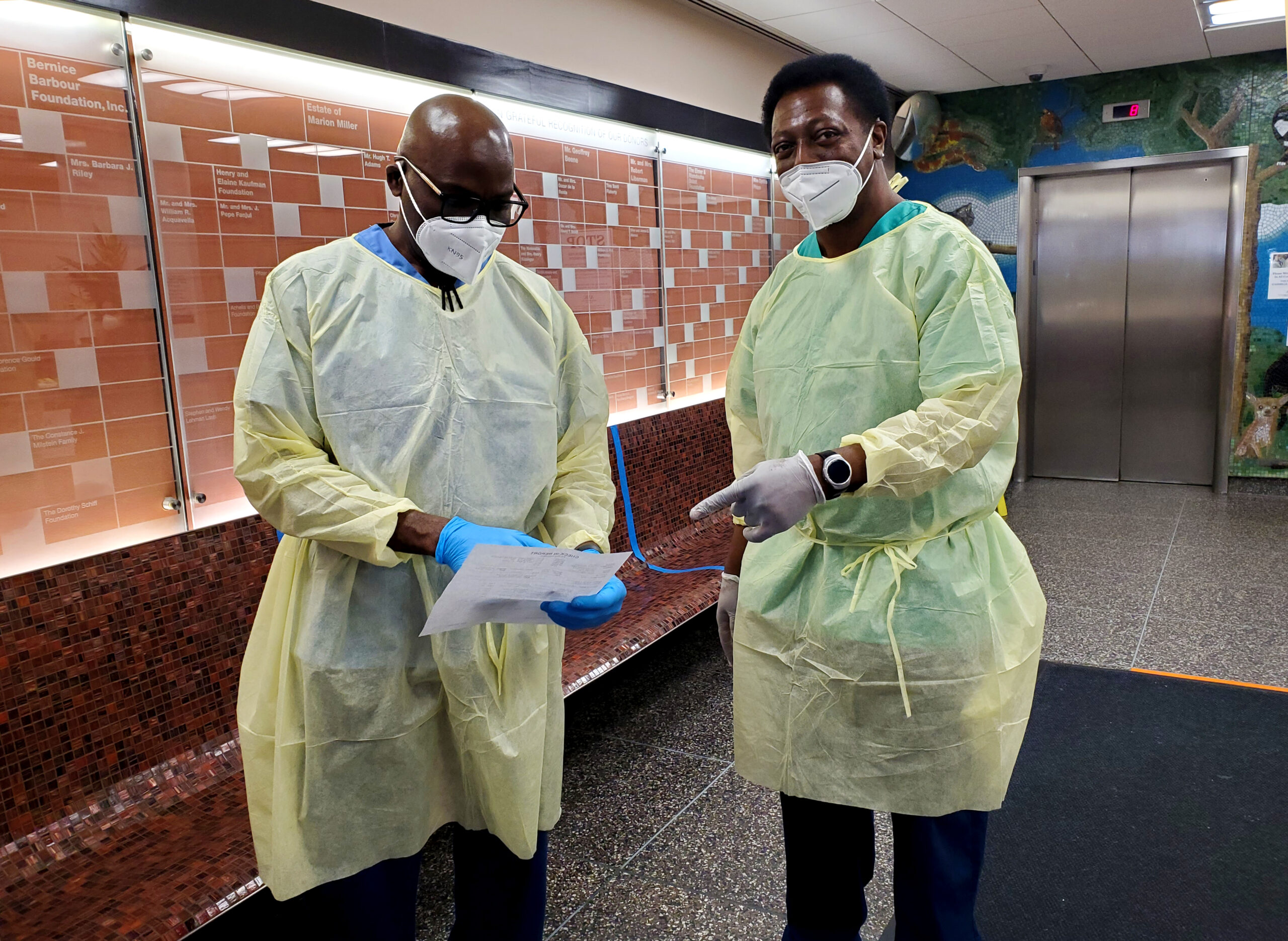 Two masked veterinary professionals stand in the lobby of the Animal Medical Center of New York City