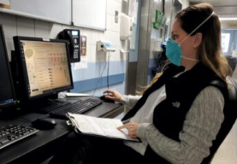 A veterinary professional on the phone while wearing a mask