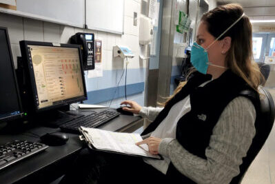 A veterinary professional on the phone while wearing a mask