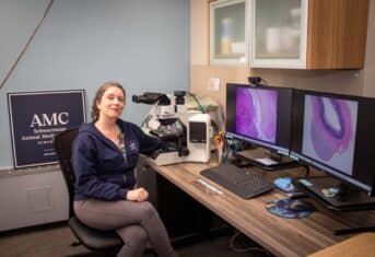 A veterinary pathologist in front of a computer